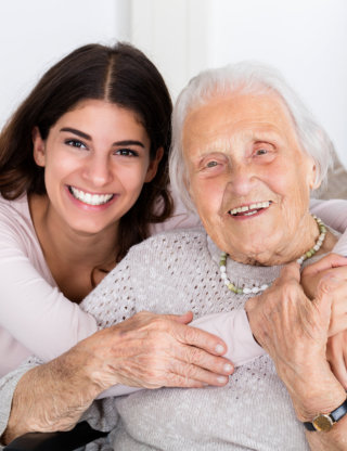 caregiver hugging senior woman