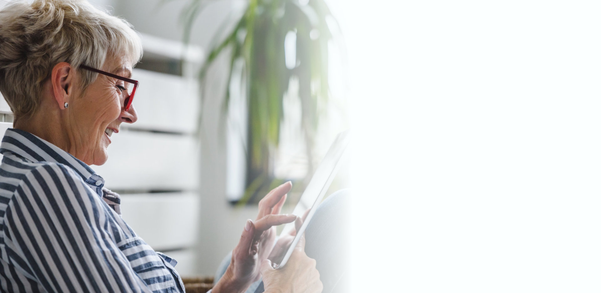 Senior woman using digital tablet at home