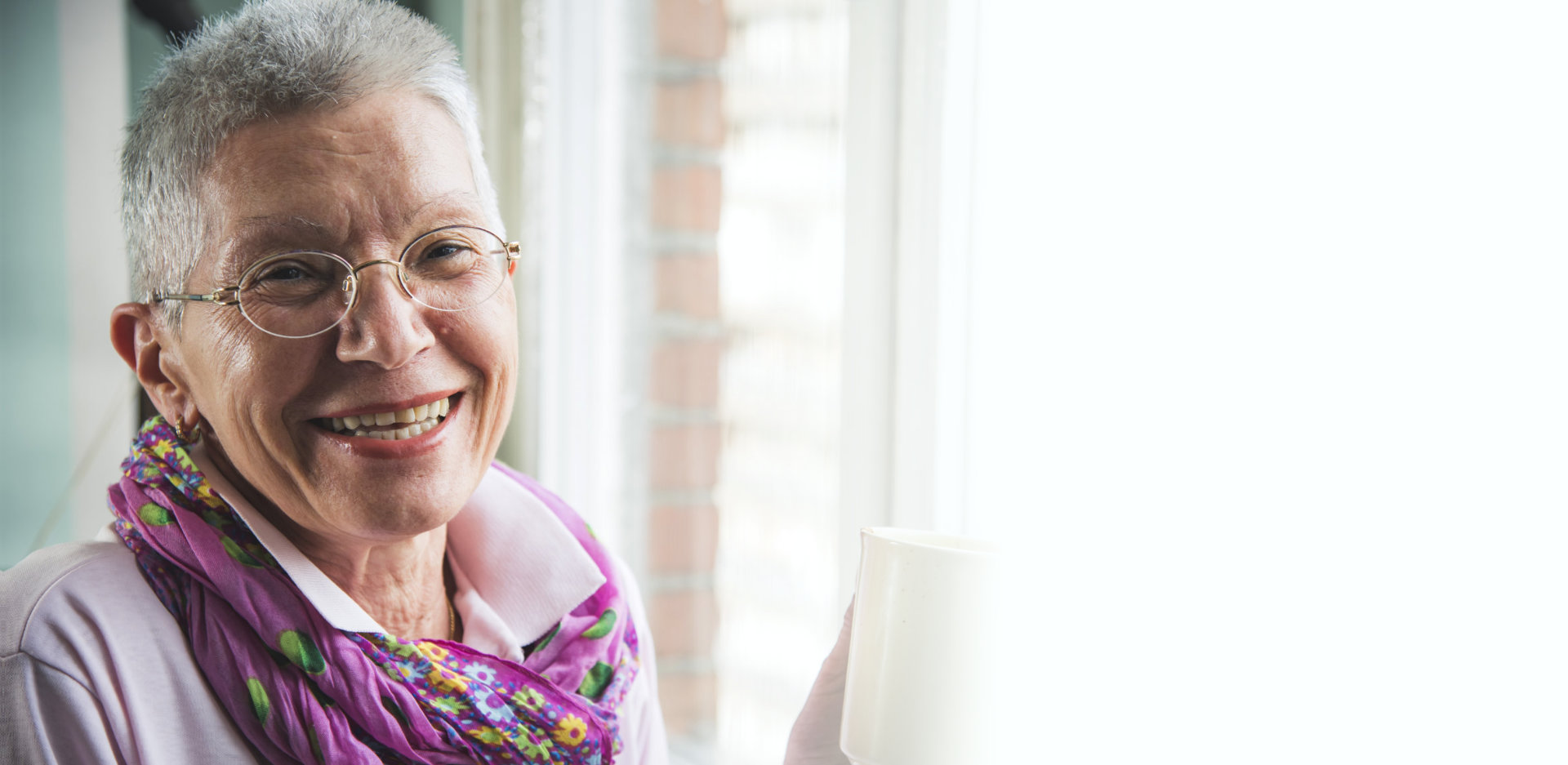 Old senior woman drinking a warm beverage