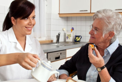 woman pouring milk for elderly woman